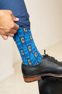man pulling sock up. UCO sock with blue and gold C